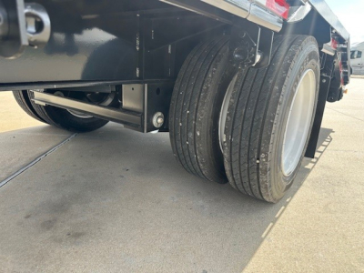 Trailer rear dual tires and undercarriage with metal support bar visible