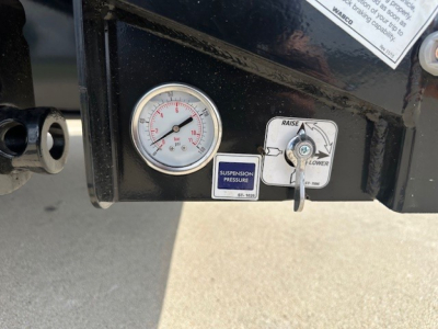 Trailer gauge panel showing a round pressure gauge and a suspension pressure label with a small lever and label reading SUSPENSION PRESSURE.