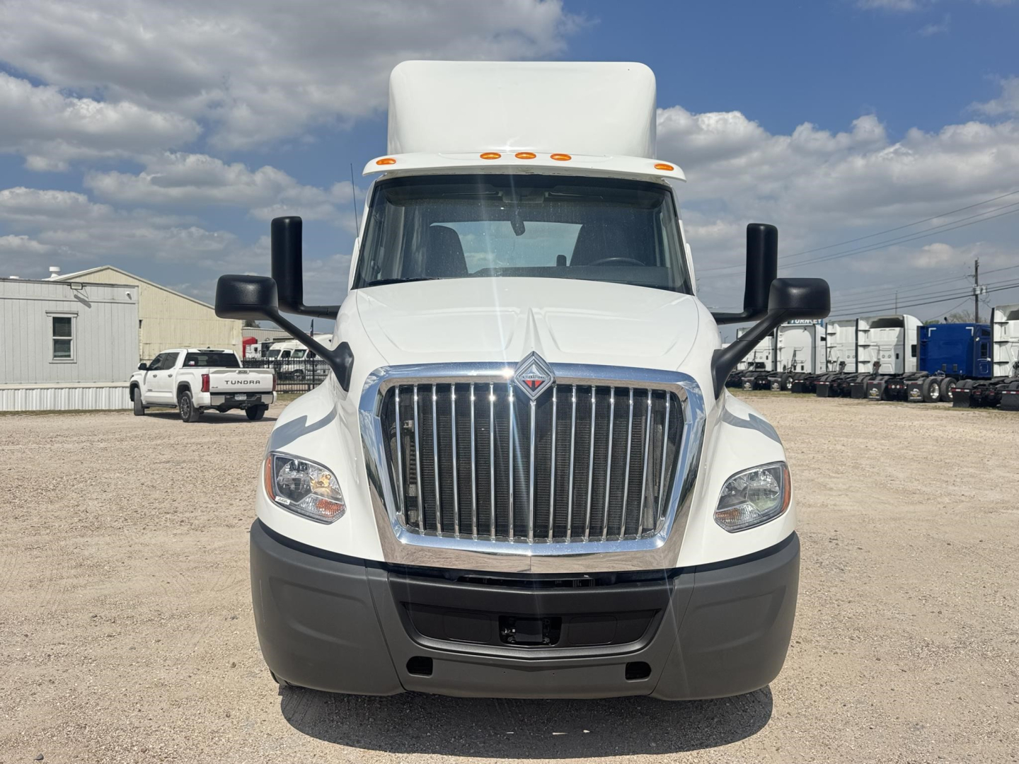 Front view of a white 2019 International LT daycab truck showing large chrome grille, black bumper, and dual side mirrors.