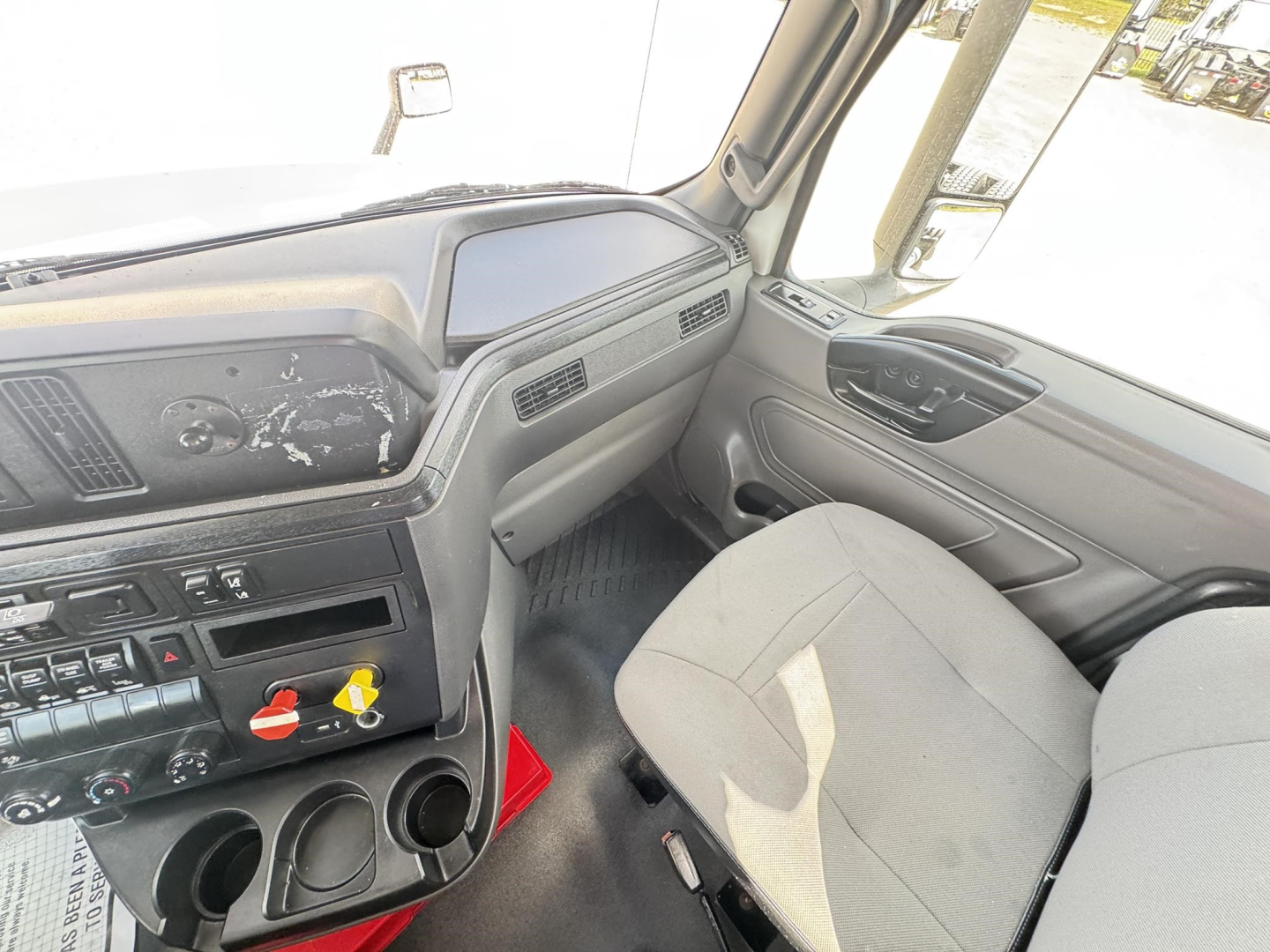 Interior of a 2019 International LT daycab showing dashboard switches, steering wheel area, and front passenger seat.