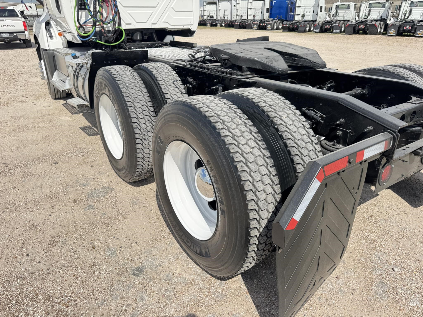 Truck rear chassis with dual rear axles and mud flaps on a used 2019 International LT daycab showing twin tires and wheel rims.