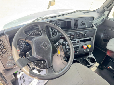 Interior of a 2019 International LT daycab truck cabin showing steering wheel, dashboard, control panel, and driver seat with gear shifter visible.