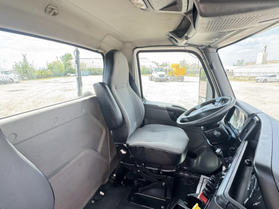 Truck cab interior of a 2019 International LT daycab showing driver's seat, steering wheel, dashboard, and side window.