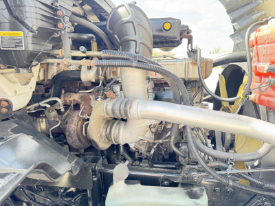 Truck engine bay showing labeled components and hoses; visible text includes caution sticker and various hoses and turbo lines.