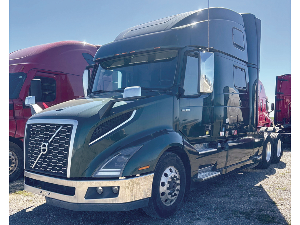 Volvo VNL 860 sleeper tractor truck in dark green showing front grille, bumper, chrome trim, and side mirrors; two-tone cab with aerodynamic roof fairing.