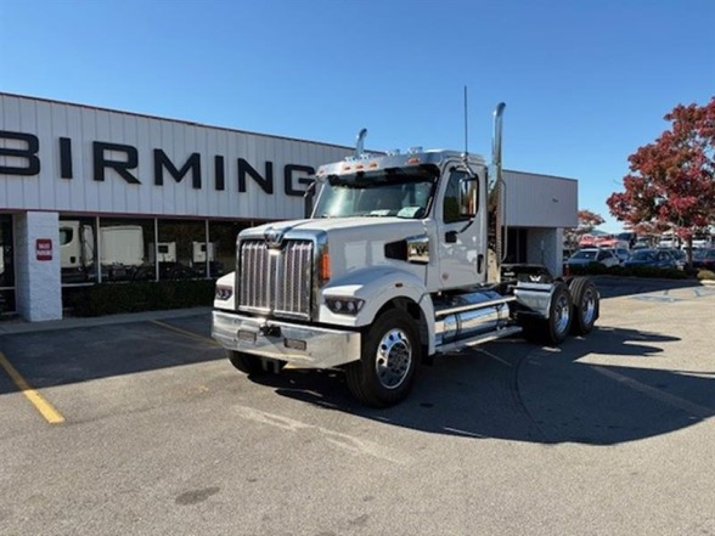 New 2026 Western Star 49X day cab truck in a dealership lot, chrome exhaust stacks, large front grille, cab and chassis setup.