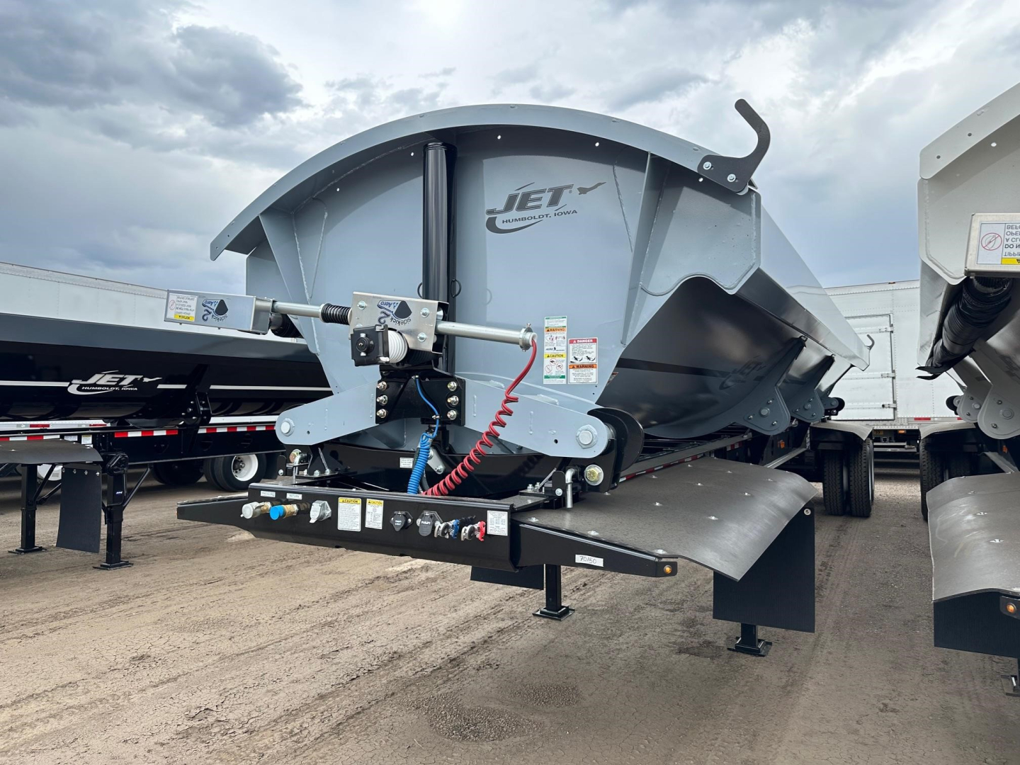 Jet 40' air ride side dump trailer with electric tarp system and 2-way valve, shown from left-front side, with Jet logo on gray steel dump body and hydraulic components visible.