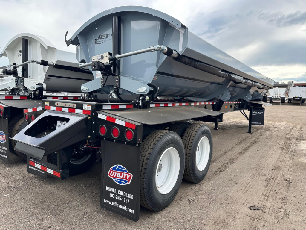 Jet 40' air ride side dump trailer with electric tarp and 2-way valve, dual rear axles, gray steel hopper, black undercarriage, white wheels, Utility branding visible.