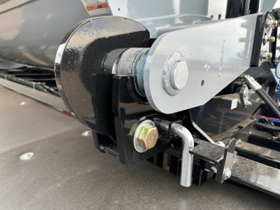 Trailer axle and coupling hardware with electric tarp system components visible, including hinge pin, bolt, and hitch area of a 2026 Jet 40' air ride side dump trailer.