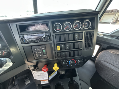 Dashboard of a 2026 Mack GR64B roll-off truck showing instrument gauges, control switches, and an open slot for radio/climate controls.