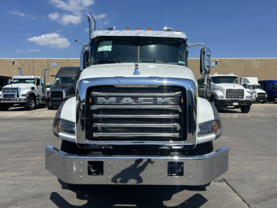 Front view of a white 2026 Mack GR64B rolloff truck showing large chrome grille with MACK emblem, bumper, and side mirrors.