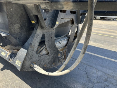 Bottom dump trailer hitch area showing hydraulic hose and steel frame components