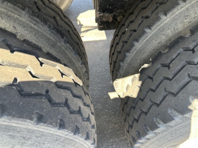 Dual truck tires showing tread in a bottom-dump trailer undercarriage. 