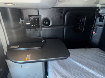 Kenworth T680 sleeper cab interior with small fold-out table and electrical panel in view.