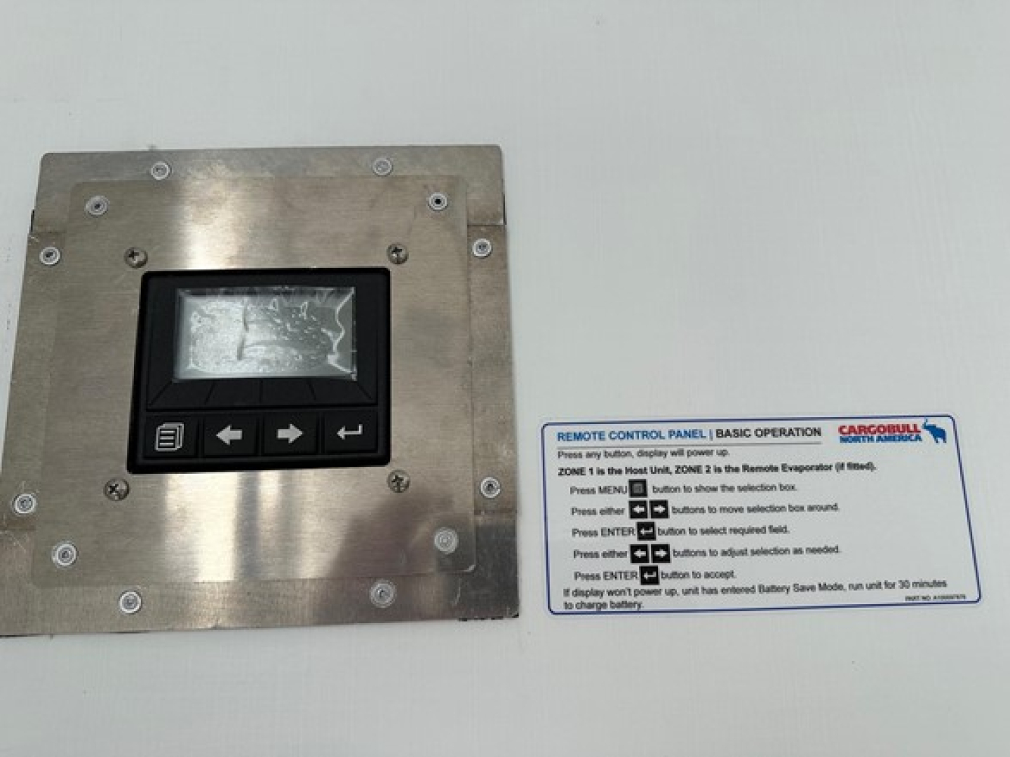 Equipment control panel with digital display and instruction label on a metal plate.