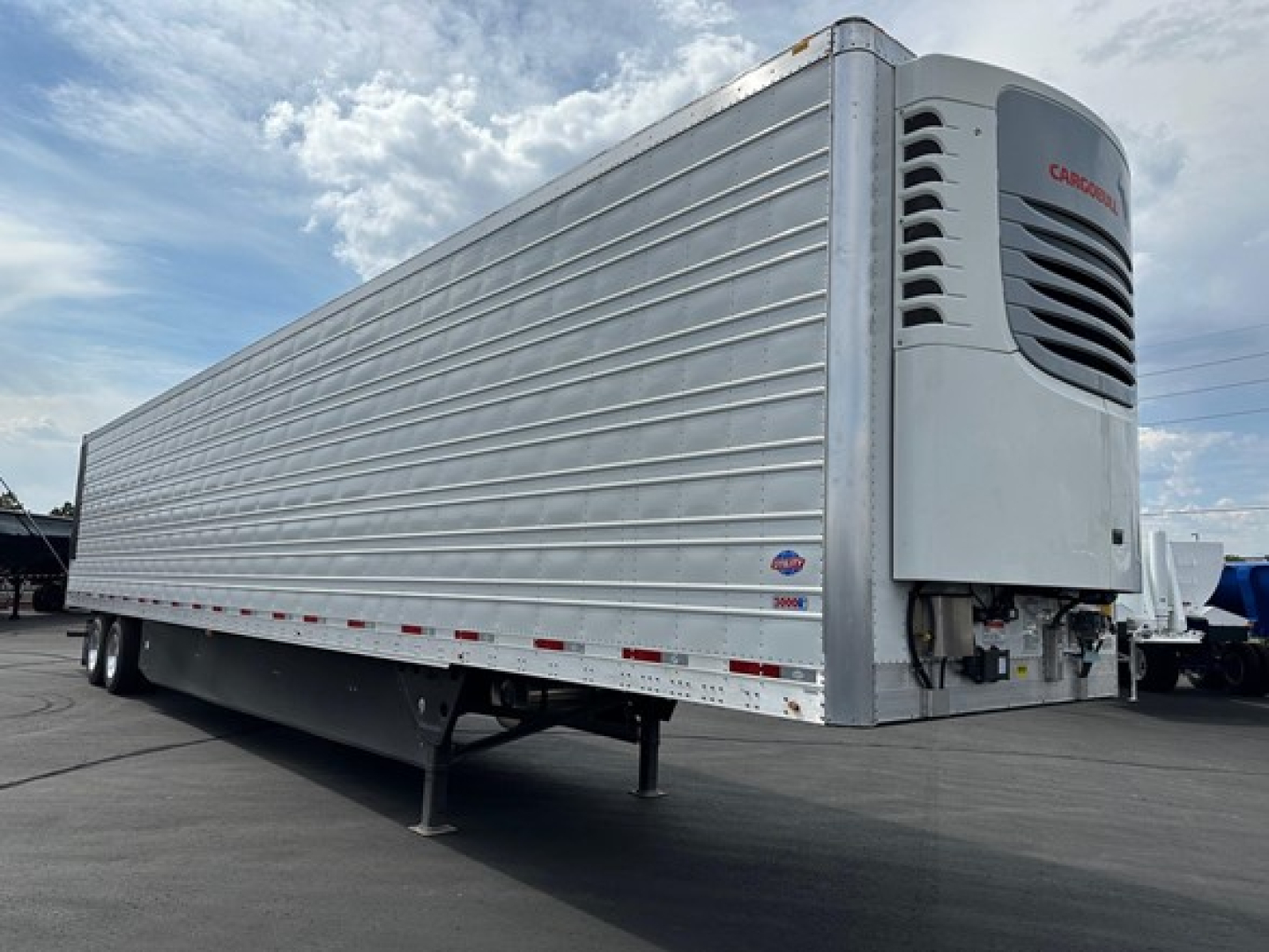 Utility trailer with a large refrigeration unit at the front, side-ribbed aluminum body, dual rear axles, and a white/Cargerson cooling unit with vents visible.
