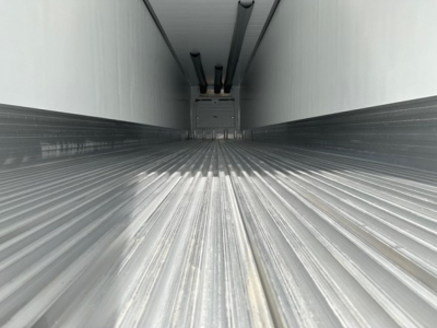 Trailer interior view of a 2027 Utility Cargo Bull 625 refrigerated trailer, ribbed metal floor, side walls, and diagram at far end.