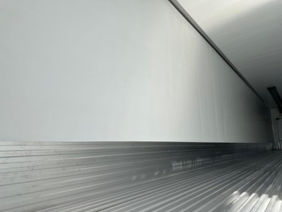 Trailer interior with ribbed metal floor and smooth sidewall; no visible text or labels.