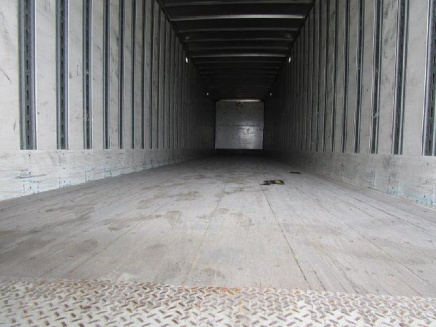 Stoughton van trailer interior showing empty cargo space with wooden floor and metal sidewalls, lengthy rectangular trailer interior perspective.
