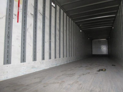 Interior of a 2014 Stoughton van trailer with empty cargo area, wooden floor, steel side walls, and rear door at far end.