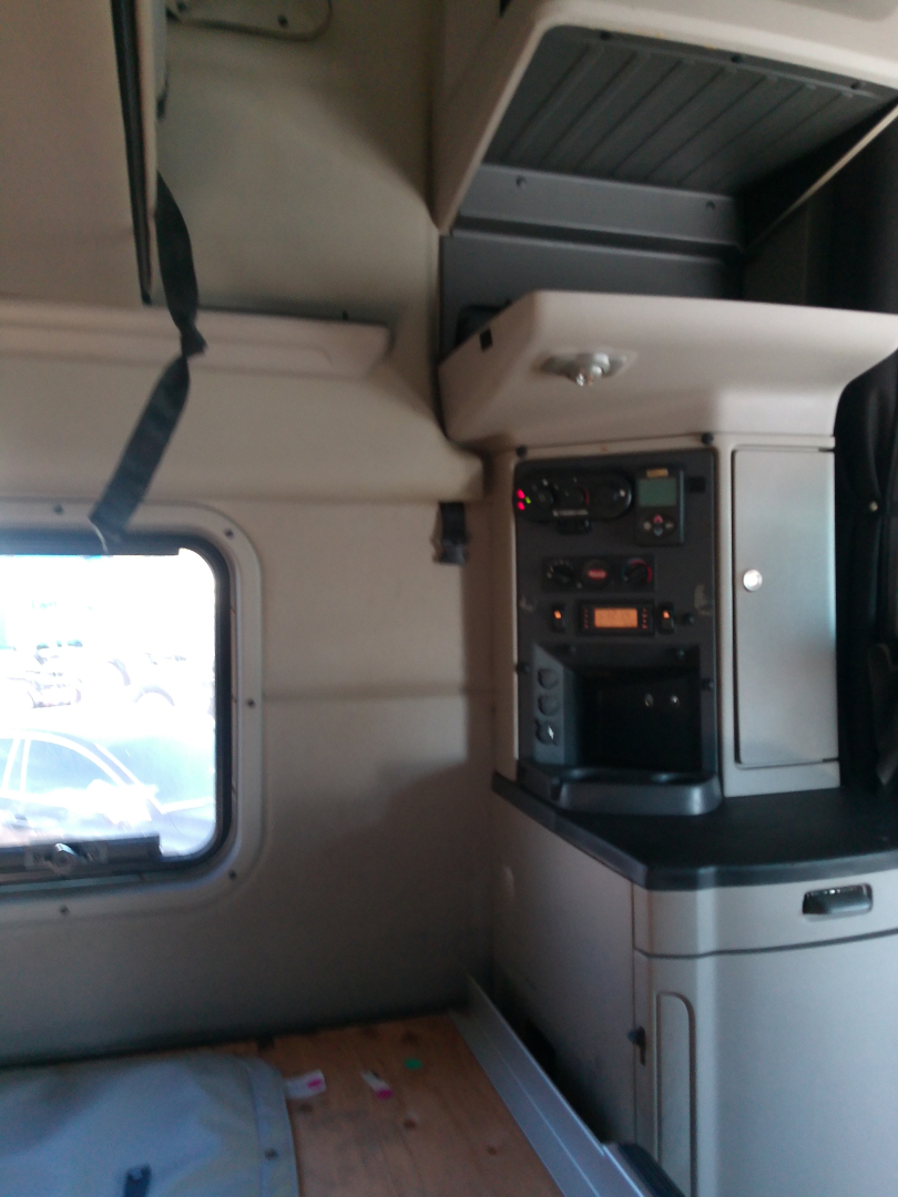 Peterbilt 579 cabin interior showing dashboard controls and overhead storage in-view.