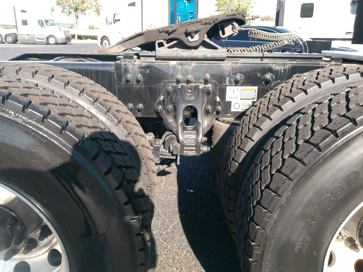 Peterbilt truck chassis area showing dual rear wheels and fifth wheel coupling with visible frame and suspension components.