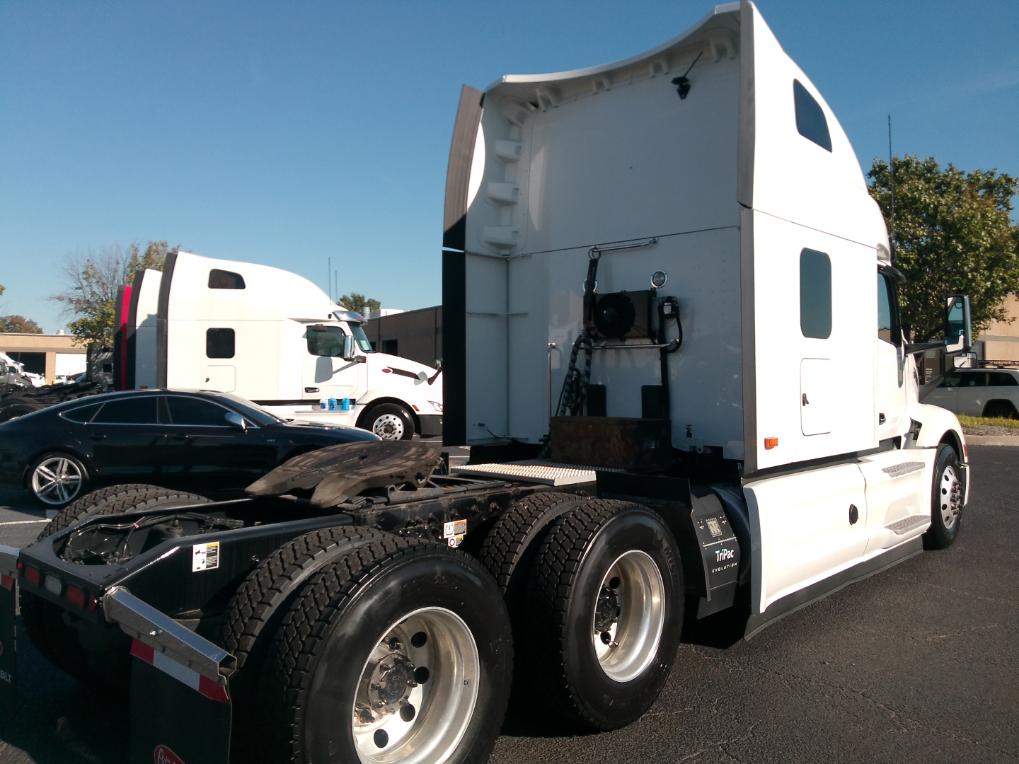Peterbilt 579 sleeper cab truck with white exterior, visible rear wheel axles, and raised sleeper area.