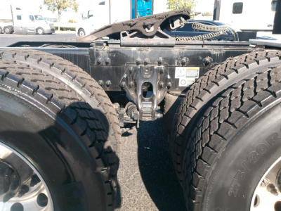 Peterbilt truck chassis area showing dual rear wheels and fifth wheel coupling with visible frame and suspension components.