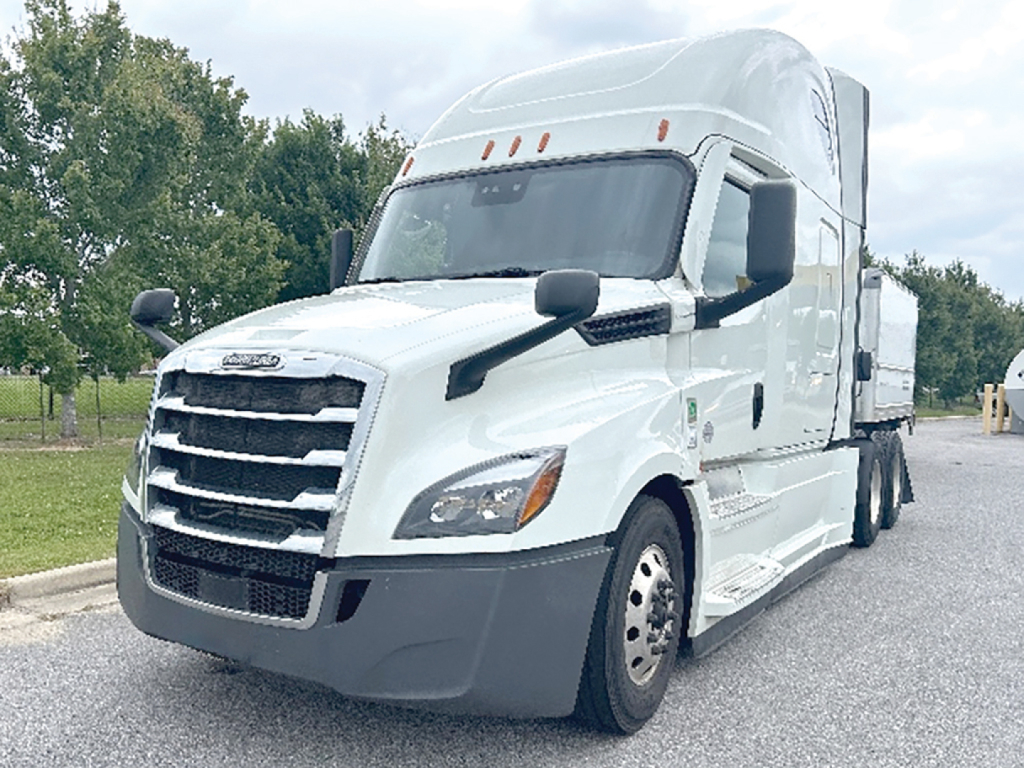 Freightliner Cascadia126 sleeper truck showing front grille, headlights, and cab with white exterior and large side mirrors.