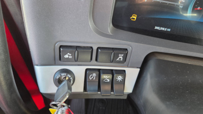Kenworth T680 instrument cluster and control panel showing switches and dashboard; ignition key inserted and dashboard display visible.