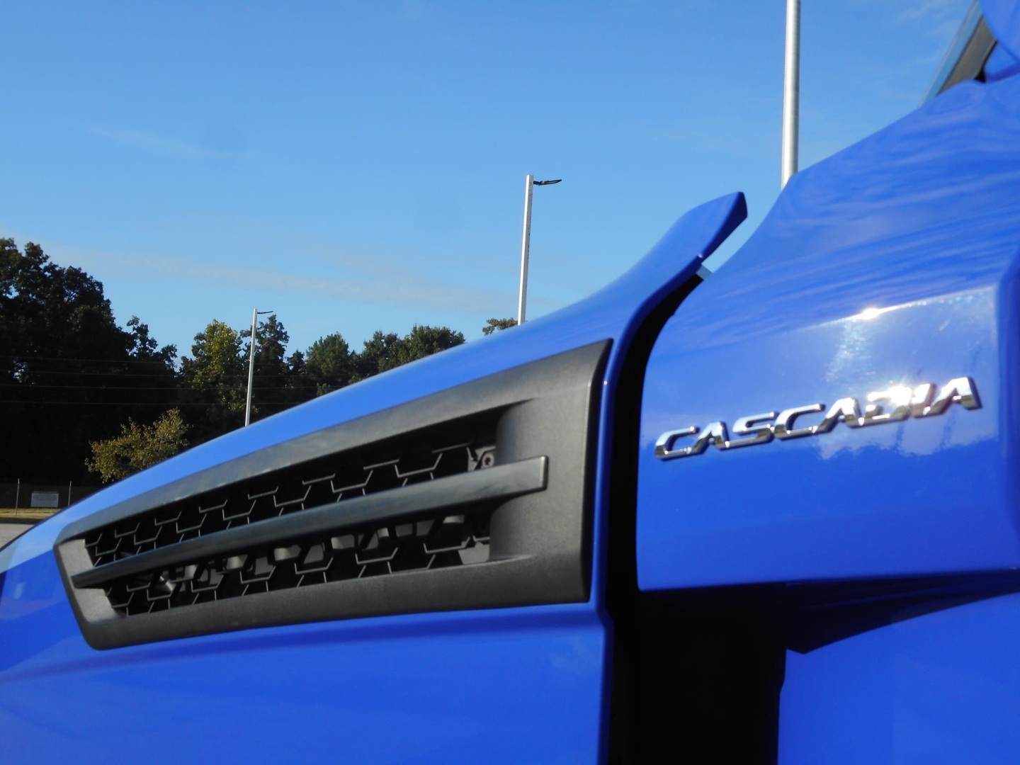 Blue Freightliner Cascadia 126 engine bay with Cascadia badge visible on the side.
