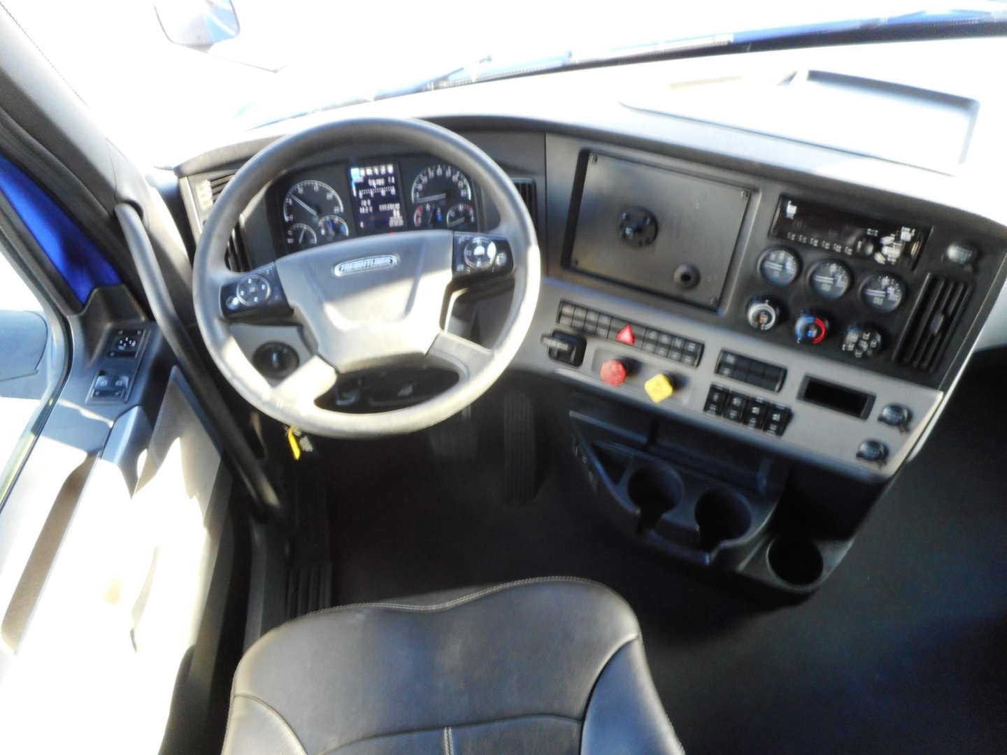Dashboard and steering wheel of a 2022 Freightliner Cascadia 126 truck interior showing gauges, steering wheel, and control panel.