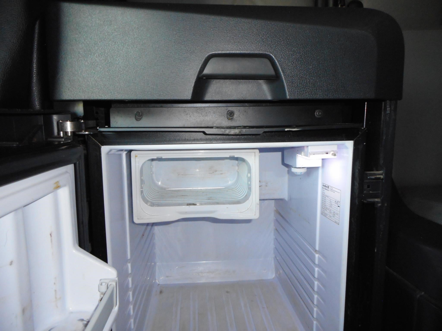 Freightliner Cascadia 126 truck cab interior showing a small refrigerator/freezer unit mounted in the sleeper area.