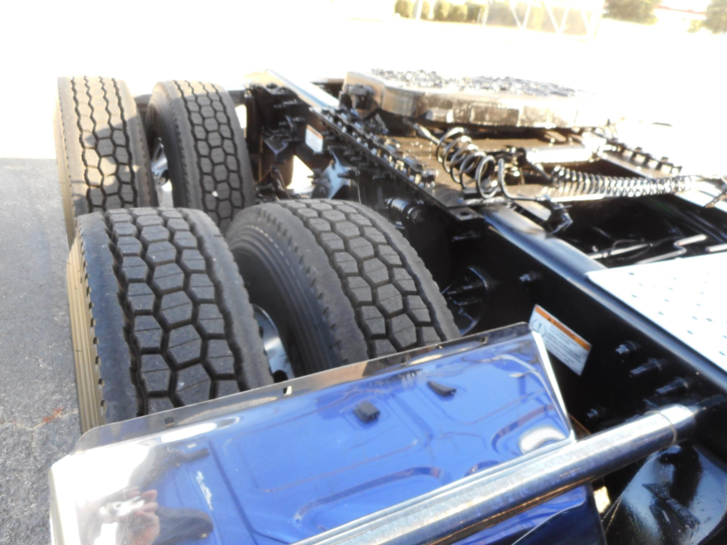 Freightliner Cascadia truck chassis and dual rear axles showing tires and suspension components.
