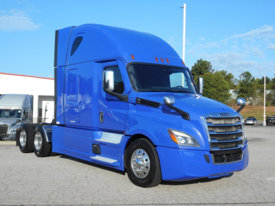 Freightliner Cascadia 126 tractor in blue, front three-quarter view, aerodynamic sleeper cab with chrome grille and mirrors.