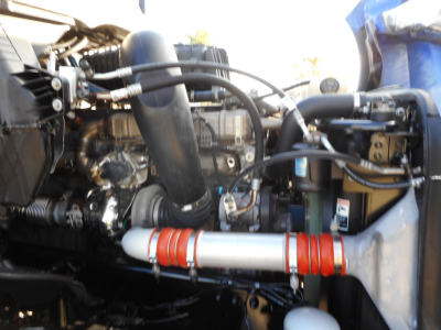 Freightliner Cascadia engine bay showing turbocharger and intercooler piping with red silicone hose and metallic exhaust components.