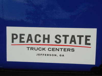 Frieghtliner Cascadia truck sticker 'Peach State Truck Centers Jefferson, GA' on blue cab panel.