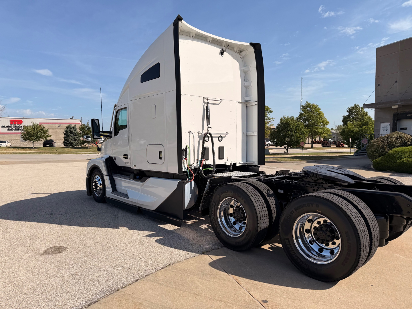 Kenworth T680 tractor with open sleeper cabin, dual rear axles, chrome wheels; side view showing cab interior and door; no visible labels or fluid reservoirs in this angle.