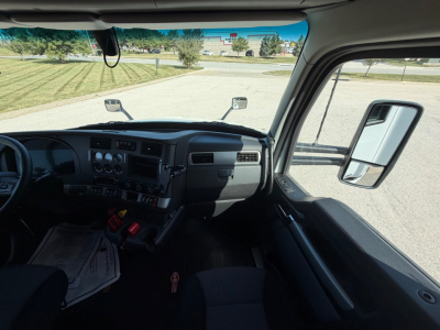 Kenworth T680 truck cabin interior view from the driver's seat showing dashboard controls, steering wheel, side mirror, and windshield.