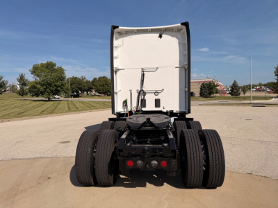 Kenworth T680 tractor rear view showing dual rear axles and fifth wheel, white cab interior visible, no trailer attached.