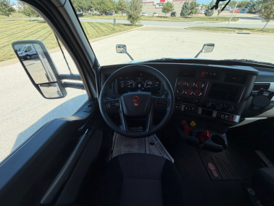 Kenworth T680 truck interior dashboard view from driver seat showing steering wheel, instrument cluster, and center console.