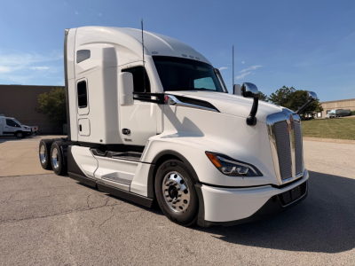Kenworth.T680 tractor in white, front-left angle, featuring sleeper cab, chrome wheel covers, Aerodynamic mirrors; no visible labels or sticker text legible on the truck exterior.