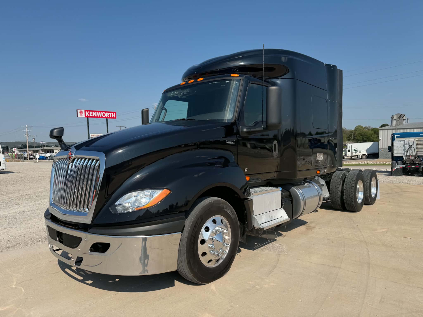 2023 International LT625 conventional sleeper truck in black, front-left view, showing chrome bumper, grille, and dual rear axles.