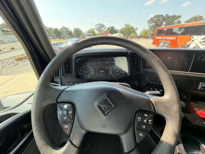 Cab interior of a 2023 International LT625 truck showing steering wheel with controls and gauge cluster