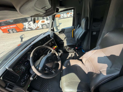 Truck cab interior showing steering wheel, driver's seat, and dashboard of a 2023 International LT625 truck.