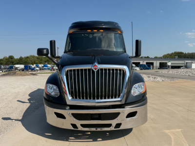 Truck front view showing International LT625 badge on grille, large chrome grille, black hood, headlights, bumper with fog lights, and side mirrors.