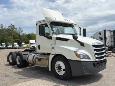 Truck cab showcases Freightliner Cascadia 126 daycab with white paint and extended hood, front grille, dual rear axles, daycab configuration.