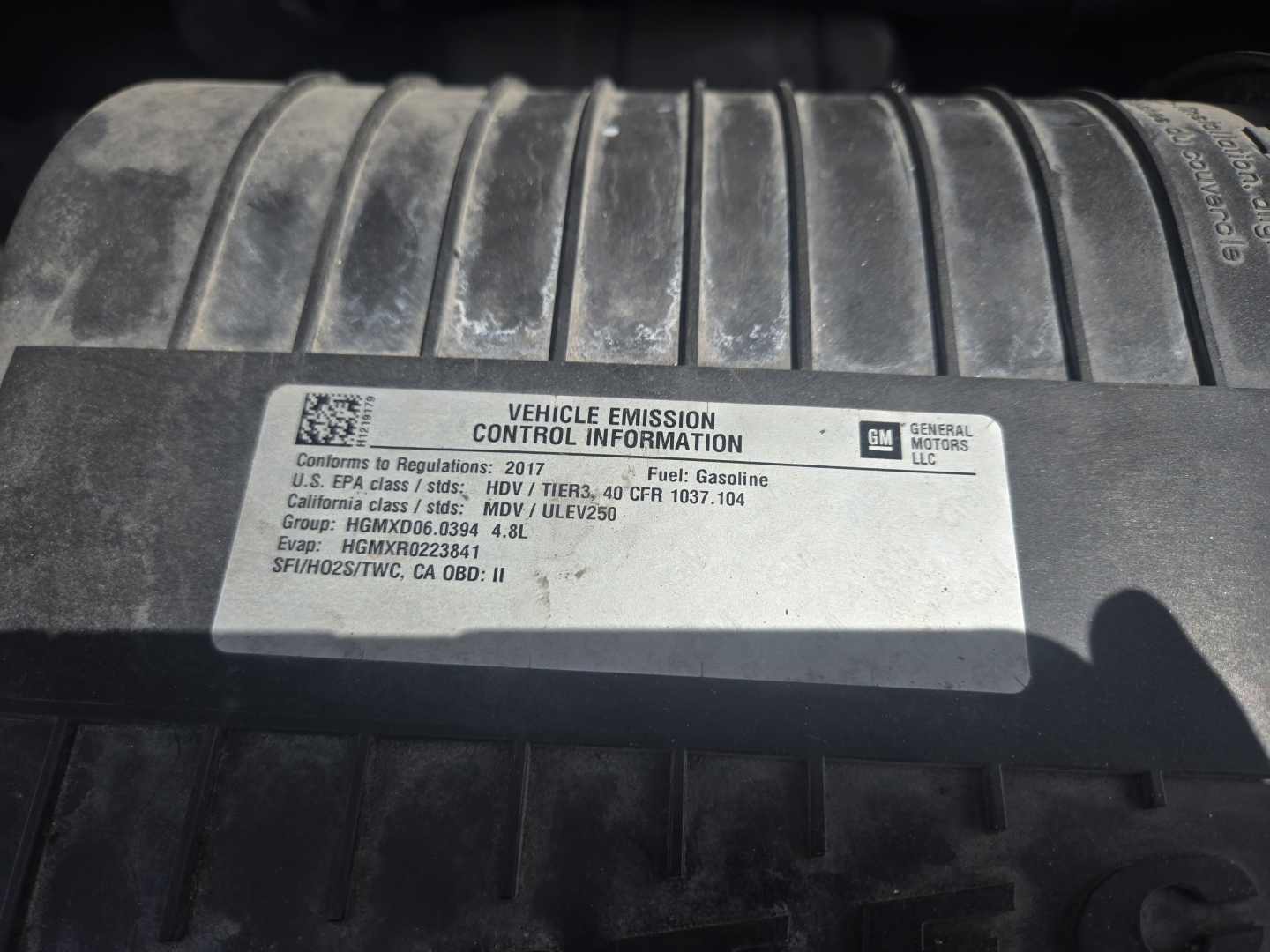 Vehicle Emission Control Information label on Chevrolet Express 3500 engine bay cover showing GM logo and regulatory details.