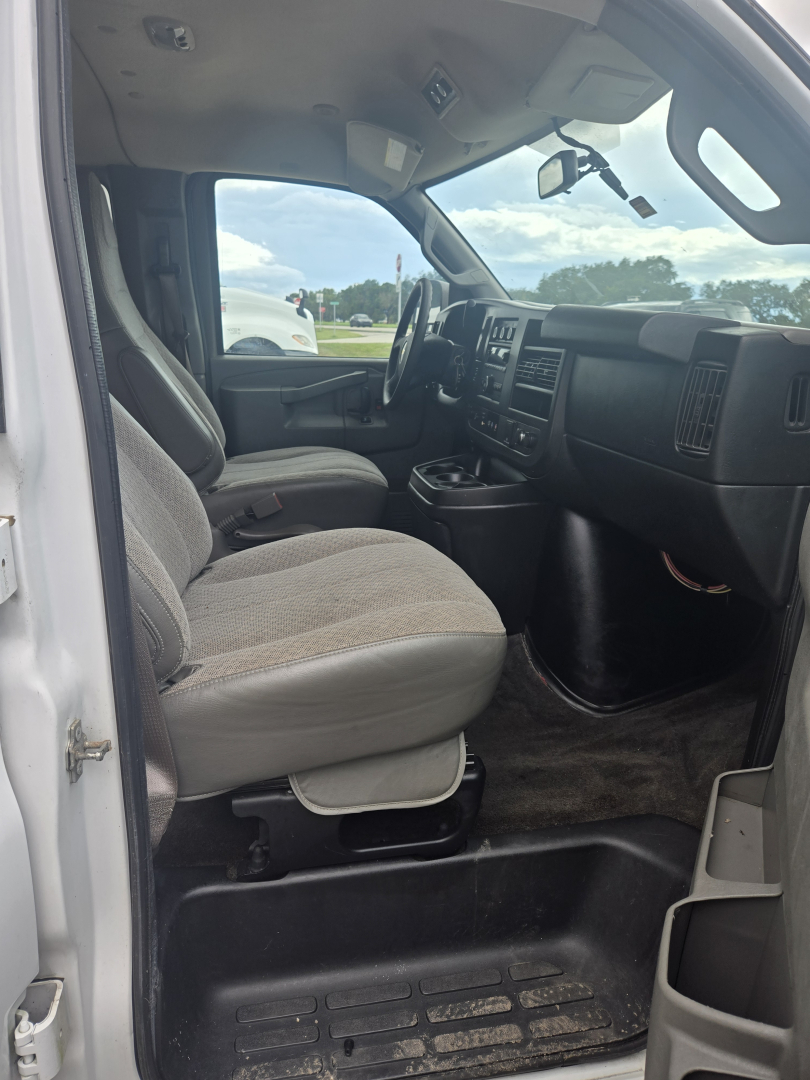 Interior of a 2017 Chevrolet Express 3500 cargo/passenger van showing front seats, dashboard, and steering wheel from the driver’s side.