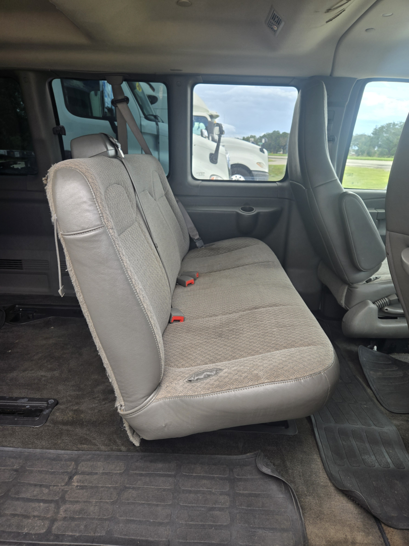 Chevrolet Express 3500 interior rear seating view, passenger van with fabric bench seats and seat belts visible
